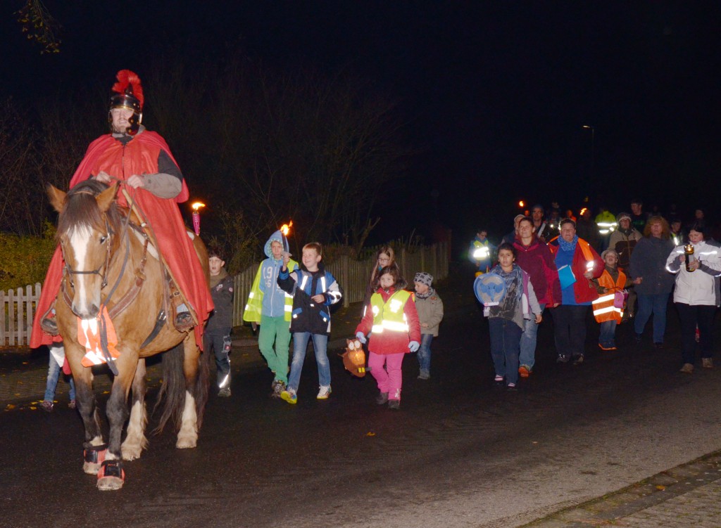 Sankt Martinsumzug mit Pferd und Kindern mit Laternen ziehen durch den Ort