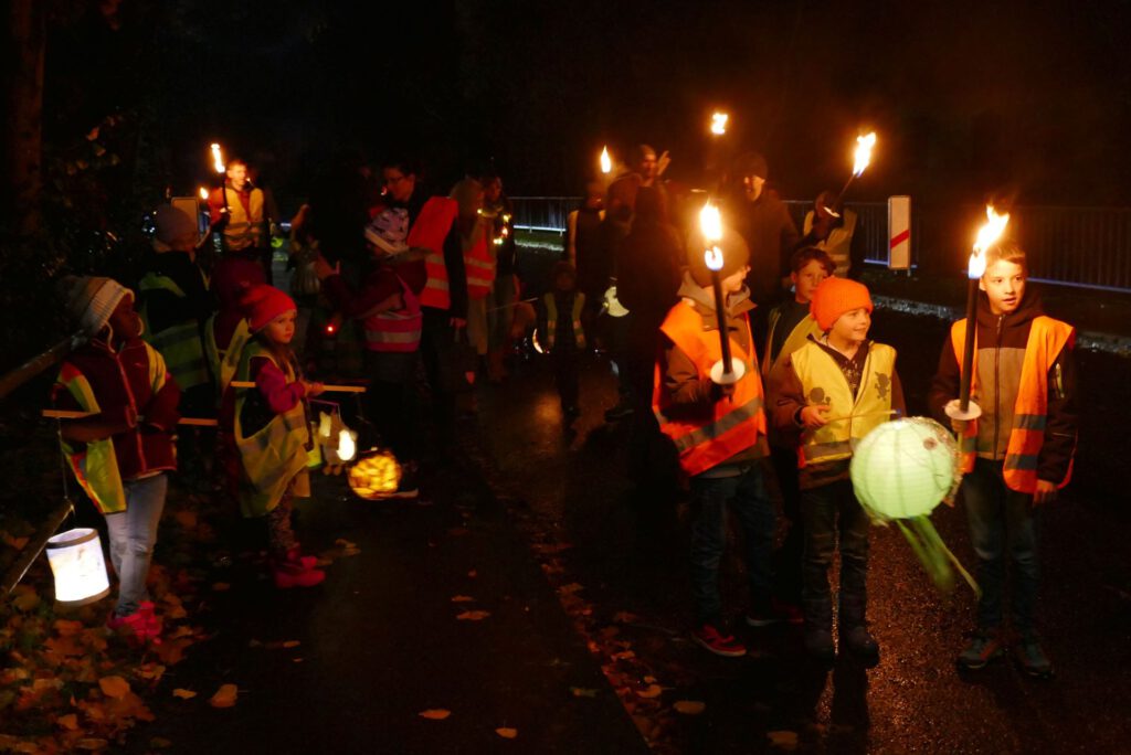 Sankt Martinsumzug 2023 | Die Kinder gehen mit ihren Martinslichter singend durch die Dunkelheit. | Foto: Alexandra Lüß